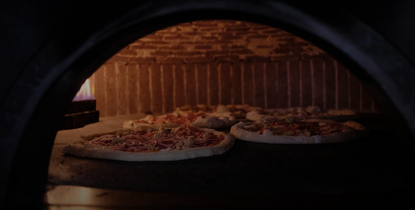 Pizza che si gonfia e si abbrustolisce nella fiamma viva del forno a legna di Visciano